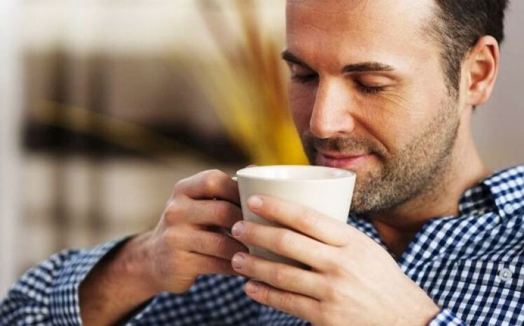 A man drinks a sip of lemon balm tea to increase potency